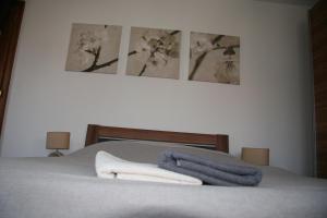 uma cama com três fotografias na parede e toalhas em B&B bio em Dieffenthal