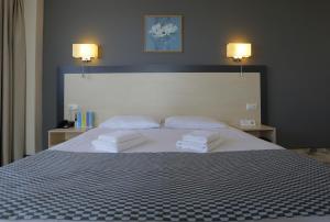 a bedroom with a large bed with two towels on it at Aurora Hotel Klaipeda in Klaipėda
