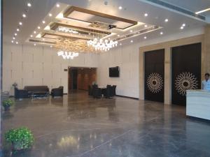 un gran vestíbulo con un gran vestíbulo con lámparas de araña en KL7 Hotel & Banquets, en Patna