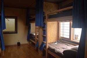 a room with two bunk beds and a mirror at Guest House Minato in Miyako