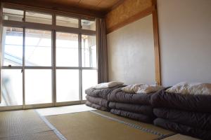 a room with two couches in front of a large window at Guest House Minato in Miyako