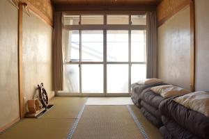 a living room with a large window and a couch at Guest House Minato in Miyako