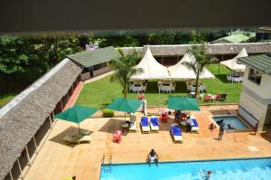 Kakamega的住宿－Golf Hotel Kakamega，享有带桌子和遮阳伞的游泳池的顶部景致