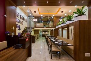 a dining room with tables and chairs in a restaurant at Hotel Ramkrishna Inn in Kolhapur