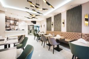 a restaurant with tables and chairs and a bar at Roxen Hotel&Spa in Chişinău