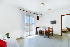 a white room with a table and a dining room at Apartments Citrus in Turanj