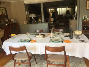 a dining table with a white tablecloth and chairs at L'Atelier Du Peintre in Ornans