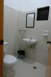 a bathroom with a toilet and a sink at Bangles Homestay in Coron