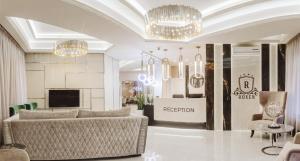 a living room with a couch and a television and chandeliers at Roxen Hotel&Spa in Chişinău