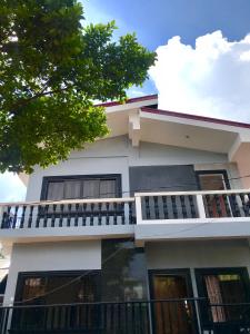 une maison avec un balcon sur le côté de celle-ci dans l'établissement Bangles Homestay, à Coron