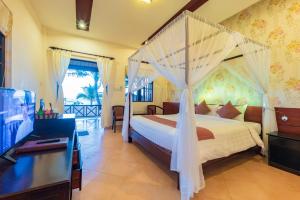 a bedroom with a bed with a mosquito net at Sea Star Resort in Phú Quốc