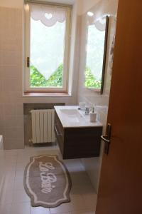łazienka z umywalką, oknem i dywanem w obiekcie B&B Villa dei Cigni Reali w mieście Carpi +25 zdjęć