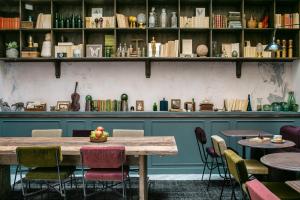 a table in a restaurant with chairs and books at La Planque Hotel in Paris