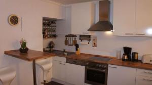 a kitchen with white cabinets and a wooden counter top at 2-Zimmer Apartment Sofia, gemütlich wie zu Hause in Offenbach +40 photos
