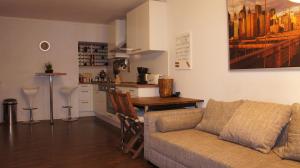 a living room with a couch and a table and a kitchen at 2-Zimmer Apartment Sofia, gemütlich wie zu Hause in Offenbach
