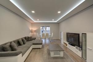 a living room with a couch and a television at Paradise Terrace House in Quinta do Conde