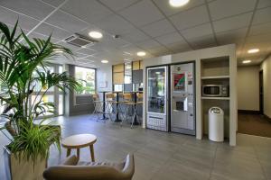 an office lobby with a vending machine and chairs at B&B HOTEL Beaune Sud 1 Palais des Congrès in Beaune