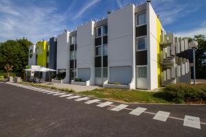 un bâtiment situé sur le côté d'une route dans l'établissement B&B HOTEL Beaune Sud 1 Palais des Congrès, à Beaune