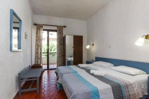 a bedroom with a bed and a chair in it at Emmanuel Apartments in Rhodes Town