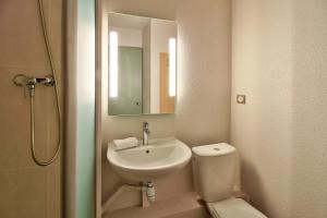 a bathroom with a sink and a toilet and a mirror at B&B Hôtel BEAUNE Sud (1) Palais des Congrès in Beaune