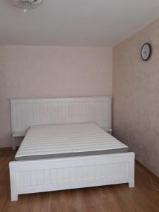 セストロレツクにある350 Приморское шоссеの白いベッド(壁に時計付)