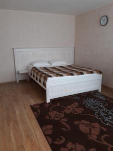 セストロレツクにある350 Приморское шоссеのベッドルーム1室(ベッド1台、ラグ、時計付)