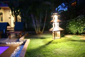 a garden with a light in the grass at night at Villa Angelica Bed and Breakfast in Phuket in Bang Tao Beach