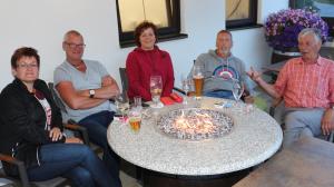 um grupo de pessoas sentadas à volta de uma mesa com um bolo em Das kleine Berghotel em Liesing