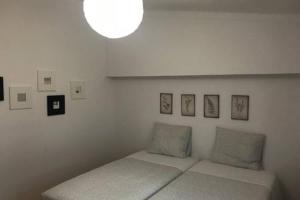 a white room with a bed with pictures on the wall at Casa da Avó Tita in Cardeal