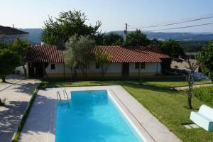 a swimming pool in front of a house at Casa da Avó Tita in Cardeal