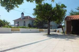 a house with a tree in the middle of a driveway at Casa da Avó Tita in Cardeal