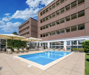 a swimming pool in front of a building at Best Western Plus Hotel Farnese in Parma