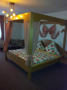 Schlafzimmer mit einem Holzbett mit Baldachin in der Unterkunft Moselhotel Waldeck in Burgen