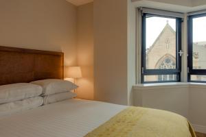 a bedroom with a bed and a window at PREMIER SUITES PLUS Glasgow Bath Street in Glasgow