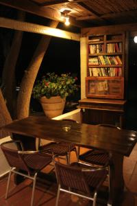 a wooden table with chairs and a book shelf with books at Classic Apartments in Hersonissos