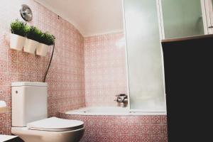 a bathroom with a toilet and a bath tub at Beach House São Pedro in São Pedro do Estoril