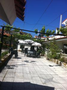 un patio con mesas, sillas y sombrillas en Hotel Casa Portuguesa, en Loures