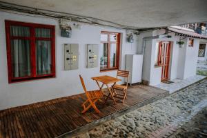 einen Holztisch und Stühle auf einer Veranda eines Hauses in der Unterkunft Central am Brukenthal in Sibiu