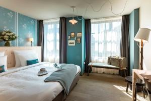 ein Schlafzimmer mit einem großen Bett mit blauen Wänden in der Unterkunft Marias Platzl in München
