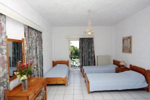 a room with two beds and a table at Classic Apartments in Hersonissos +27 photos