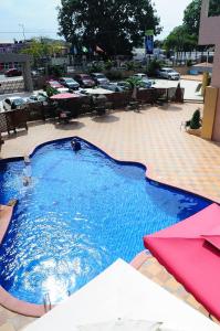 a large blue swimming pool with tables and chairs at Tomreik Hotel in Accra