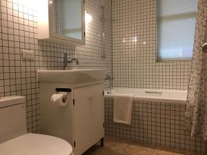 un bagno con lavandino, WC e vasca di American Village Resort a Taipei