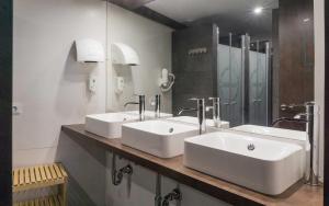 a bathroom with two sinks and a large mirror at TAKE SURF Hostel Conil in Conil de la Frontera