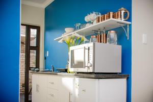 a kitchen with blue walls and a microwave on a counter at Camello in George