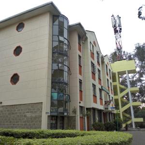 an apartment building with a glass facade and a building at Adventist LMS Guest House & Conference Centre in Nairobi