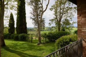 una vista dal portico di una casa con alberi e erba di Borgo Lucignanello Bandini a San Giovanni dʼAsso