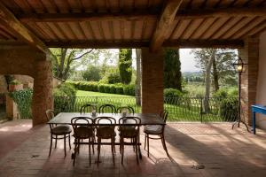 a wooden table and chairs on a patio at Borgo Lucignanello Bandini in San Giovanni dʼAsso
