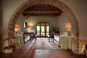 une voûte dans un salon avec des tables et des chaises dans l'établissement Borgo Lucignanello Bandini, à San Giovanni dʼAsso