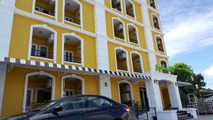 ein vor einem gelben Gebäude geparkt in der Unterkunft Garden Hill Hotel in Trang