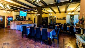 a restaurant with tables and chairs and a bar at Pensiunea Denisa in Lunca Bradului